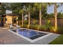 Backyard pool with lounge area, outdoor fireplace, lush tropical landscaping, and privacy fencing at 507 Mccants Dr, Mount Pleasant, SC 29464
