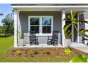 Inviting front porch with rocking chairs, manicured flower beds, and charming curb appeal at 5115 Cranesbill Way, Johns Island, SC 29455