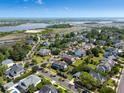 An aerial view shows a neighborhood with lush green trees and manicured lawns, near a river and a bridge at 601 King Haven Ln, Johns Island, SC 29455