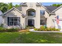 Charming home exterior featuring a well-manicured lawn and a striking arched entryway at 6242 Fieldstone Cir, Charleston, SC 29414