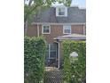 Brick house featuring dormer windows, a wrought iron gate, and lush green hedges surrounding the property at 70 Legare St, Charleston, SC 29401