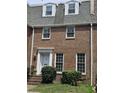 Traditional brick home featuring a white front door, symmetrically balanced windows, and manicured bushes at 70 Legare St, Charleston, SC 29401