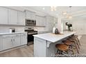 Well-equipped kitchen features gray cabinets, a spacious island with bar stools, and stainless steel appliances at 714 N Hickory St # 13, Summerville, SC 29483