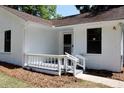 Inviting front entrance with charming porch railing and freshly painted white brick facade at 7774 Ginger Ln, North Charleston, SC 29420