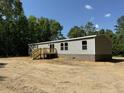 Side view of a manufactured home with grey siding, brick skirting, a small porch and wood deck at 852 Lawyer Ln, Cross, SC 29436