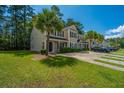 Two-story townhome with well-manicured lawn, a paved driveway, and mature landscaping at 9098 Maple Grove Dr, Summerville, SC 29485
