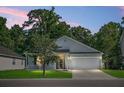 Inviting single-story home with a two-car garage, cozy front porch, and a lush, green lawn at 1026 Briar Rose Ln, Ladson, SC 29456
