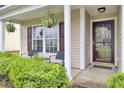 Inviting front porch with hanging ferns, seating, and a welcoming 'hello there' doormat at 108 Larkspur Dr, Goose Creek, SC 29445