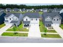 An aerial view of a residential neighborhood featuring charming homes, green lawns, and a scenic pond at 112 Whisper Dr, Summerville, SC 29485