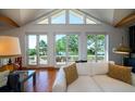 Bright living room featuring vaulted ceilings, hardwood floors, and expansive windows with scenic outdoor views at 1195 Framptons Inlet Rd, Edisto Island, SC 29438