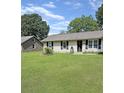 Traditional home with a well-kept lawn, black shutters, and charming curb appeal at 1207 Saint Johns Ave, Moncks Corner, SC 29461