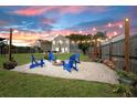 Relaxing backyard with gravel fire pit and string lights, surrounded by green lawn and privacy fence at 160 Brookhaven Rd, Summerville, SC 29486