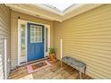 Covered front porch with a blue door, wooden deck, and white trim detailing at 1918 Piper Dr, Charleston, SC 29407
