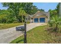 Street view of a single-story home with a well-maintained lawn, driveway, and blue two-car garage at 1918 Piper Dr, Charleston, SC 29407