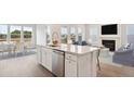 Elegant kitchen island features stone countertops and stainless steel appliances, seamlessly connecting to the living room at 212 Yalton St, Summerville, SC 29486