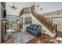 Bright living room showcases a staircase to the loft, white brick accents, and seamless transition to dining area at 2468 Marina Rd, Wadmalaw Island, SC 29487