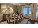 Bright dining area with large windows, chandelier, and seating for eight at 260 Huguenot Trl, Huger, SC 29450