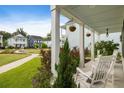 Inviting front porch with white columns and chairs, perfect for relaxing and enjoying the neighborhood views at 2747 Calico Bass Ln, Johns Island, SC 29455