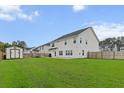 Wide view of a spacious backyard featuring a privacy fence, shed, and a manicured lawn at 277 Fiddleback Dr, Summerville, SC 29486