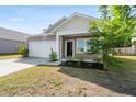 Inviting single-story home with a well-maintained lawn, tidy shrubs, and a two-car garage, ready for move-in at 309 Sedona Dr, Summerville, SC 29486