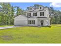 Two-story home featuring a manicured lawn, two-car garage, and classic white siding at 310 Mizell Rd, Dorchester, SC 29437