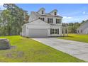 Two-story home featuring a large manicured lawn, two-car garage, and classic white siding at 310 Mizell Rd, Dorchester, SC 29437