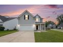 Charming two-story home with gray siding, attached garage, and well-maintained front yard at 313 Catawba Branch Way, Moncks Corner, SC 29461