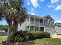 Charming two-story home with a double porch, manicured lawn, and palm tree at 346 Cicadas Song, Moncks Corner, SC 29461