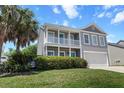 Charming two-story home with a double porch, manicured lawn, and palm tree at 346 Cicadas Song, Moncks Corner, SC 29461