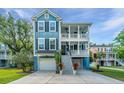 Two-story home with double porches, a two-car garage, and flower planters in front at 3711 Tip Ln, Mount Pleasant, SC 29466