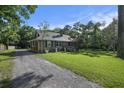 A charming house with a gravel driveway, well-maintained lawn, and mature trees at 417 Dennis Ave, Moncks Corner, SC 29461