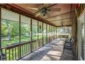 Covered porch featuring ceiling fans, chairs, and a swing, with views of the yard at 417 Dennis Ave, Moncks Corner, SC 29461