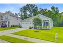 Charming single-story home featuring a manicured lawn, attached two-car garage, and a welcoming front porch at 578 Mountain Laurel Cir, Goose Creek, SC 29445