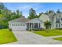 Charming single-story home featuring a manicured lawn, attached two-car garage, and a welcoming front porch at 578 Mountain Laurel Cir, Goose Creek, SC 29445