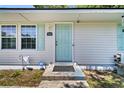 Close up of the white house's light blue front door, number, and front porch at 5806 Robinhood Dr, Hanahan, SC 29410