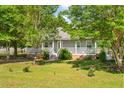 A lush, green lawn surrounds this cozy home, complemented by mature trees, a classic porch, and vibrant landscaping at 617 Willdrew Ln, Moncks Corner, SC 29461
