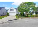 Attractive white home featuring a well-kept lawn, an attached garage, and a basketball hoop on the driveway at 7302 Sanderling Ct, Hanahan, SC 29410