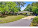 Spacious home with a long driveway, lush lawn, and mature trees, offering privacy and curb appeal at 734 Fort Sumter Dr, Charleston, SC 29412