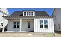 Charming single-story home featuring a covered porch, black roof, and bright white siding at 827 Gentle Breeze Dr, Summerville, SC 29486