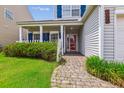 Inviting front porch with brick pathway, white picket fence, and beautiful landscaping and shrubs at 1007 Whitlow Blvd, Summerville, SC 29483