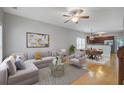 Open-concept living room boasts stylish furniture, a ceiling fan, and seamless flow into the dining area and kitchen at 116 Venezia Ct, Ladson, SC 29456