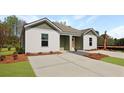Inviting duplex exterior showcasing a spacious driveway and tastefully landscaped grounds at 119 Mims Academy Dr, Harleyville, SC 29448