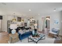 Bright open-concept living space with hardwood floors, modern lighting, and seamless flow to the kitchen at 128 Falaise St, Charleston, SC 29492