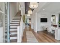 Inviting foyer featuring hardwood floors, staircase, desk area and stylish lighting fixtures at 140 Falaise St, Charleston, SC 29492