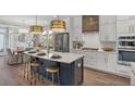 Modern kitchen with a center island, stainless steel appliances, and an adjacent dining area at 140 Falaise St, Charleston, SC 29492