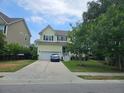 Charming two-story home with a well-manicured lawn, attached garage, and a blue car parked in the driveway at 1495 Keshi Pearl Dr, Mount Pleasant, SC 29466