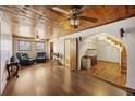 Cozy living room with knotty wood ceilings, hardwood floors, ceiling fans, and an arched doorway to stairs at 1520 Acacia St, Charleston, SC 29407