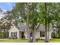 Quaint home with mature trees, a cozy front porch, and an American flag at 1583 Southwick Dr, Johns Island, SC 29455