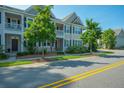 Charming townhome exterior with a small front porch, sidewalk and yellow line street at 1876 Towne St, Johns Island, SC 29455