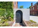 Exterior shot of a charming black door with brick steps and lush green foliage at 2 Francis St # I, Charleston, SC 29403